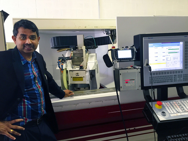 CNC Onestop Président, M. Ven Swaminathan en face de la machine de broyage retrofited.