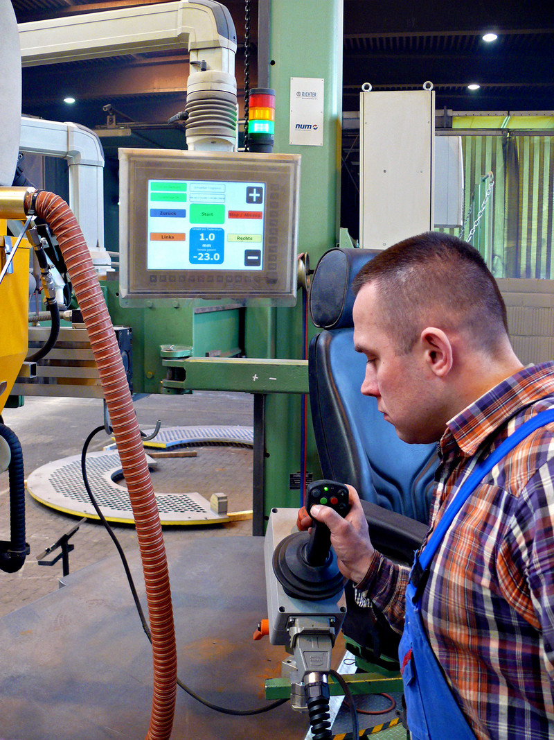 Operaio che imposta il sistema per il processo di saldatura utilizzando il joystick.