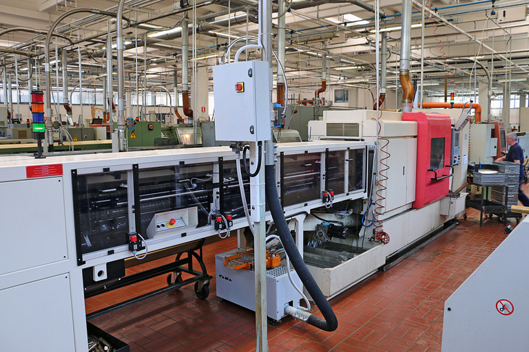 Die vollständig automatische CNC-Drehmaschine mit mehreren Spindeln AUTOR AGM 635-642 mit ihren Vorrichtungen für die Stabtrennung und Zuführung.