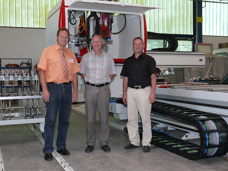 Dieter Dresler (IMA), Günter Redeker (IMA) et Alexander Helmes (NUM) devant une machine IMA equipée avec NUM (droite à gauche).
