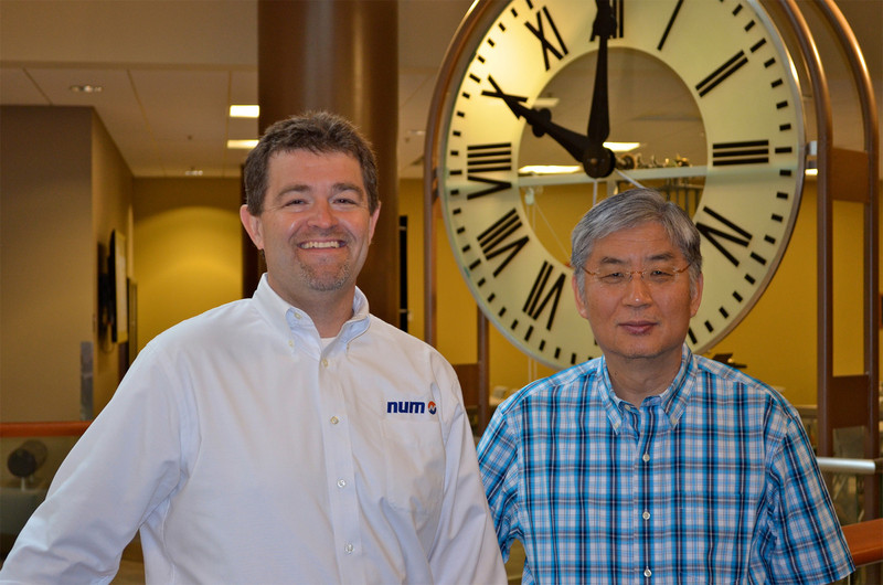 Steven Schilling (left), Managing Director of NUM Corporation, and Yung C. Shin (right), Professor of Mechanical Engineering at Purdue University, standing in front of the university’s historic Heavilon Hall clock.