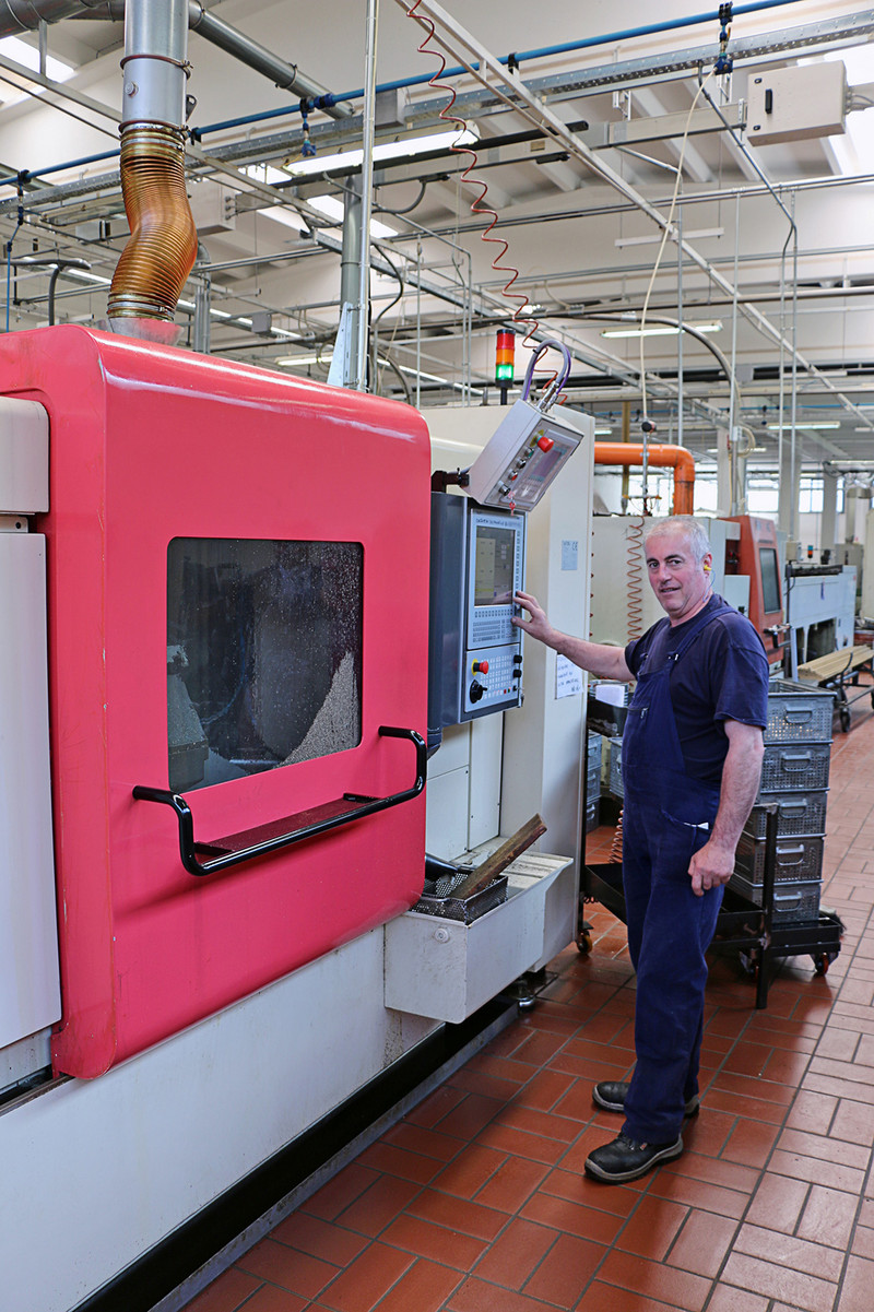 Un operatore che aziona la macchina dal pannello di comando CNC NUM Flexium 68.