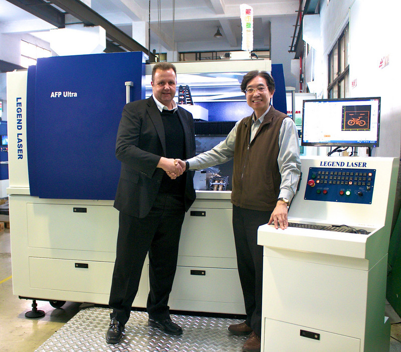 Von rechts nach links: Herr Sherman Kuo, Präsident von Legend Laser und Herr Adrian Kiener, CSO Asia und Managing Director von NUM Taiwan, stehen vor dem neuen Präzisionsblechschneidsystem SRC-610 von Legend Laser.